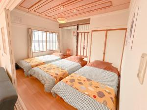 a bedroom with three beds in a room at リニューアル天然温泉マンイの湯 in Shiraoi