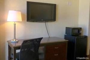 a room with a desk with a computer and a tv at Lemon Heights Inn in Tustin