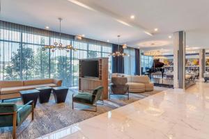 a lobby with a living room with a couch and a television at Cambria Hotel Waco University Riverfront in Waco