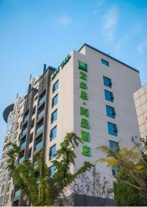 un bâtiment avec une enseigne sur le côté dans l'établissement ibis Styles Yangzhou Baixiang Rd Hotel, à Yinjiahu