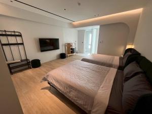 a large bedroom with two beds and a window at Chuan Inn圈旅 站前館 in Tainan