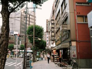 a city street with people walking down the street at THE SENSE HOTEL TOKYO in Tokyo