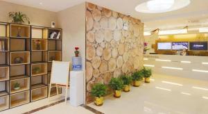 a lobby with a large stone wall and plants at GreenTree Inn Shanghai Railway Station Macao Road in Shanghai