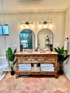 a bathroom with a wooden vanity with two mirrors at Casa Catalina - Luxury Desert Oasis in Tucson +40 photos