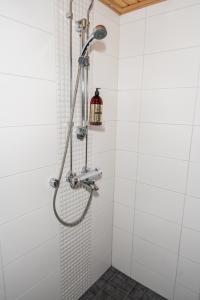 La salle de bains est pourvue d'une douche et de murs carrelés blancs. dans l'établissement Gammi Apartments - Classy Lapland Stay in Rovaniemi Centre for up to 4 Guests, à Rovaniemi