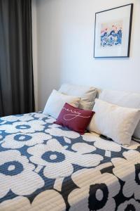 un lit avec une couverture et des oreillers noirs et blancs dans l'établissement Gammi Apartments - Classy Lapland Stay in Rovaniemi Centre for up to 4 Guests, à Rovaniemi