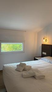 a bedroom with a white bed with two towels on it at Apartamento ALMORCHÓN - Hotel Ruta del Segur in Pontones