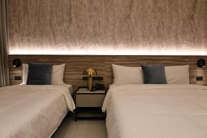 two beds sitting next to each other in a room at Fun Stay Inn Hanzhong in Taipei