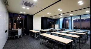een conferentiezaal met tafels, stoelen en ramen bij Kintex by K-tree in Isan