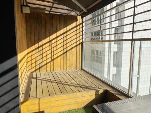 a balcony with a wooden bench and a large window at 동대문 시그니처 관광호텔 in Seoul
