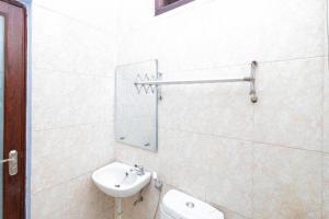ein weißes Badezimmer mit Waschbecken und Toilette in der Unterkunft RedDoorz near Wisata Museum Angkut 3 in Songgoriti + 23 Fotos