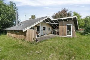 une maison avec un toit en gambrel sur un champ dans l'établissement Charming Cottage Near The Water, à Kisserup