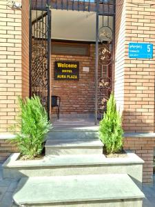 ein Gebäude mit zwei Büschen vor einer Tür in der Unterkunft Aura Plaza Hotel in Tbilisi City