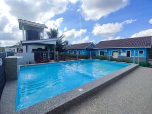 a large blue swimming pool in front of a house at Che Deris Garden Cottage with Riverview in Kota Bharu