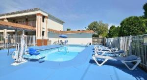 a swimming pool with two lounge chairs and a swimming pool at Days Inn by Wyndham St. Charles IL in Saint Charles