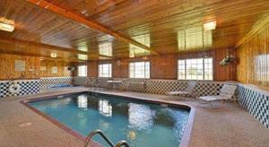 a large swimming pool in a room with a wooden ceiling at Quality Inn & Suites Grinnell near University in Grinnell
