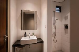 a white bathroom with a sink and a shower at Cove Heritage in Binong