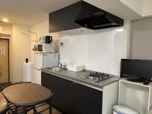 a small kitchen with a stove and a refrigerator at 板橋 RCアネックス Rc206 in Tokyo