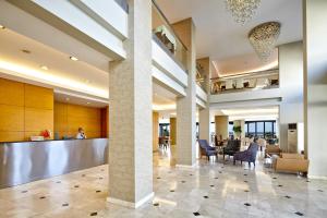 Ayvalik Cinar Hotel في أيفاليك: لوبي فندق فيه كراسي وبار