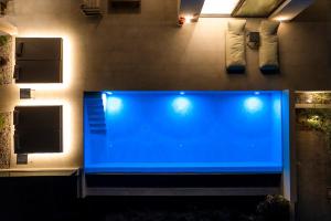 a large blue aquarium in a room with lights at Floralba Luxury Villa, Essence of Sea View Living by Mind Your Villa in Makris Gialos