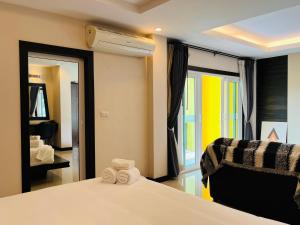 a bedroom with a bed and a chair and a window at Lulu Hotel at The Glasshouse Lion Café in Ban Sire