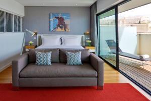 a bedroom with a couch in front of a bed at Pestana Cidadela Cascais - Pousada & Art District in Cascais