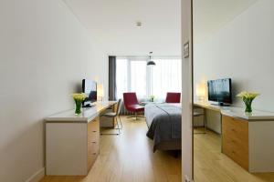 a bedroom with a bed and a desk with a television at Pestana Cidadela Cascais - Pousada & Art District in Cascais
