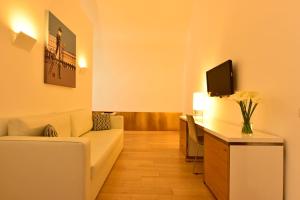 a living room with a couch and a tv at Pestana Cidadela Cascais - Pousada & Art District in Cascais