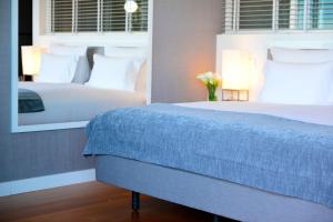 a bedroom with a large bed and a mirror at Pestana Cidadela Cascais - Pousada & Art District in Cascais