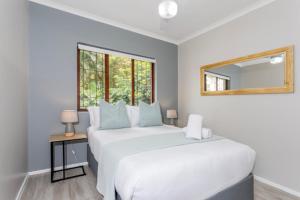a bedroom with two white beds and a mirror at 39 Kingston in Ballito +13 photos
