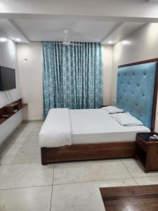 Un dormitorio con una cama grande y un televisor. en Hotel Galaxy, en Jodhpur