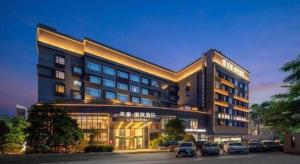 a large building with cars parked in a parking lot at Zhuhai Starlight Hotel in Zhuhai