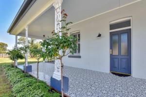 a house with a blue door and some trees at Stellaview Estate in Mitchells Flat