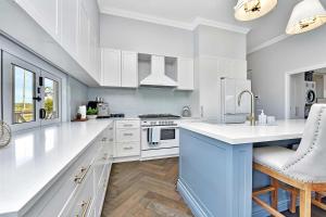 a white kitchen with white cabinets and a sink at Stellaview Estate in Mitchells Flat