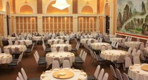 a banquet hall with white tables and chairs and a painting at Sabai Hotel Korat in Ban Khok Phai (1)