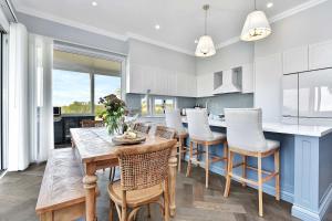 Mitchells FlatにあるStellaview Estateの木製のテーブルと椅子、カウンターのあるキッチン