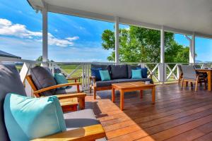a porch with couches and chairs on a wooden deck at Stellaview Estate in Mitchells Flat