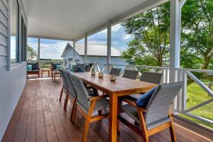 a porch with a wooden table and chairs at Stellaview Estate in Mitchells Flat