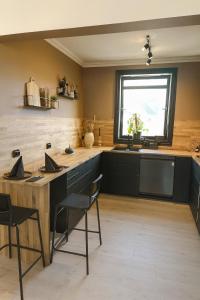 a kitchen with black cabinets and a sink and a window at A Place To Stay Stavanger, apartment 6 in Stavanger
