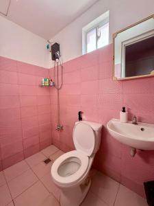 une salle de bains rose avec toilettes et lavabo. dans l'établissement Cara Transient house, à San Pablo