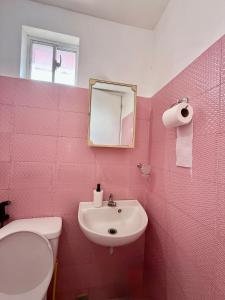 a pink bathroom with a sink and a toilet at Cara Transient house in San Pablo +28 photos