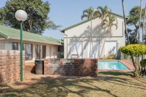 a house with a brick wall and a swimming pool at 39 Kingston in Ballito