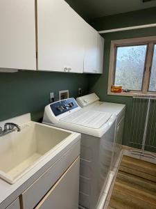 a kitchen with a sink and a washing machine at Family Vacation Home - Stunning Views across Salt Pond in Bethany Beach