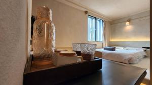 a room with a bed and a large vase on a table at 艾睏設計行旅 Sleepie Design Hotel in T'ien-liao