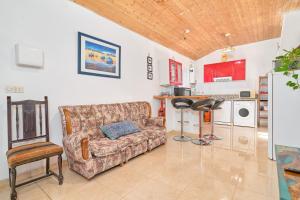 Una sala de estar con un sofá y una cocina. en Casa Papi, en Alcaucín