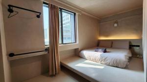 a small bedroom with a bed and a window at 艾睏設計行旅 Sleepie Design Hotel in T'ien-liao