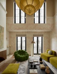 uma sala de estar com um sofá verde e um grande lustre em The Sapphire Glow Saigon-Chic Apartment with Elevator Access-Coffee 24-7 em Cidade de Ho Chi Minh