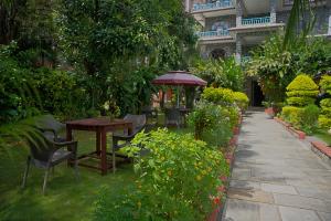 PokharaにあるHotel Lake Palaceの庭園内のパティオ(テーブル、椅子付)