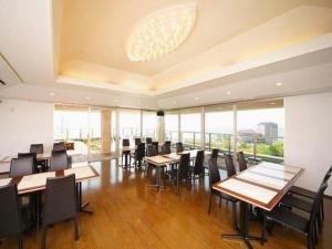 Un comedor con mesas y sillas y ventanas. en Green Hotel Yes Nagahama Minatokan, en Nagahama