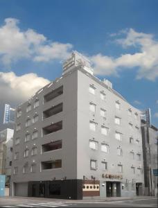 Un gran edificio blanco al costado de una calle. en Niigata Keihin Hotel, en Nuttari